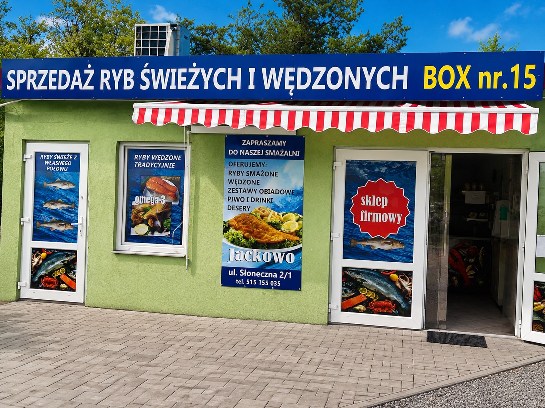 Punkt sprzedaży na przystańce rybackiej: zielony pawilon z szyldem „SPRZEDAŻ RYB ŚWIEŻYCH I WĘDZONYCH”