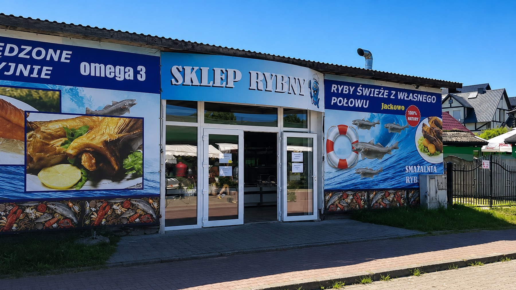 Sklep rybny Jackowo od frontu: szyld „SKLEP RYBNY” i banery z rybami