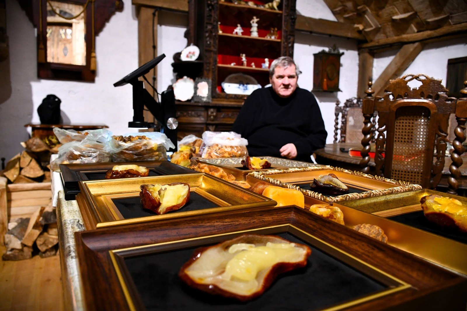 Właściciel muzeum przy oprawionych bursztynach i surowych bryłkach